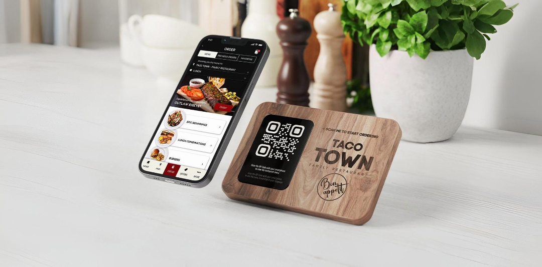 ScanBite digital menu system showing mobile app interface and QR code table stand for Taco Town Restaurant in an elegant dining setting